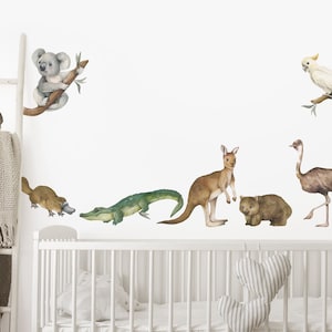 Op de afbeelding: Een set met wanddecals van Australische dieren, waaronder een koala, een kangoeroe, een wombat, een mierenegel, een vogelbekdier, een krokodil, een emoe en een kaketoe. De decals zijn in aquarelstijl gedrukt en perfect voor een kinderkamer of babykamer.