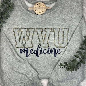 May include: Gray sweatshirt with a navy blue and yellow embroidered design that says "WVU medicine".