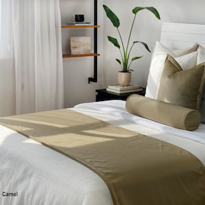 Peut inclure: Un lit avec une literie blanche, un chemin de lit couleur camel et des oreillers assortis. Un traversin cylindrique et un oreiller carr&eacute; sont sur le lit. Le mot "Camel" est dans le coin inf&eacute;rieur gauche.