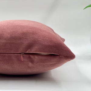 May include: A dusty rose velvet pillow cover with a zipper closure.