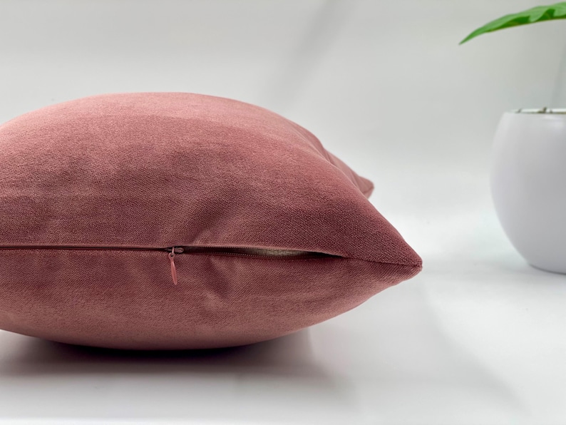 May include: A dusty rose velvet pillow cover with a zipper closure.