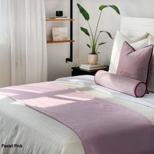 Peut inclure: Un chemin de lit rose pastel et des oreillers assortis sur un lit blanc. Le chemin de lit est drap&eacute; sur le lit et les oreillers sont dispos&eacute;s au chevet. Un traversin cylindrique est &eacute;galement pr&eacute;sent. Le texte "Pastel Pink" est dans le coin inf&eacute;rieur gauche.