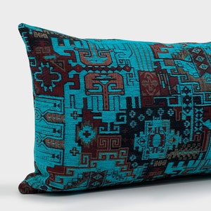 May include: A rectangular cushion featuring a teal backdrop and a geometric design in brown and black hues. The cushion has a woven texture and is designed for home decor, with a length of approximately 40 cm.
