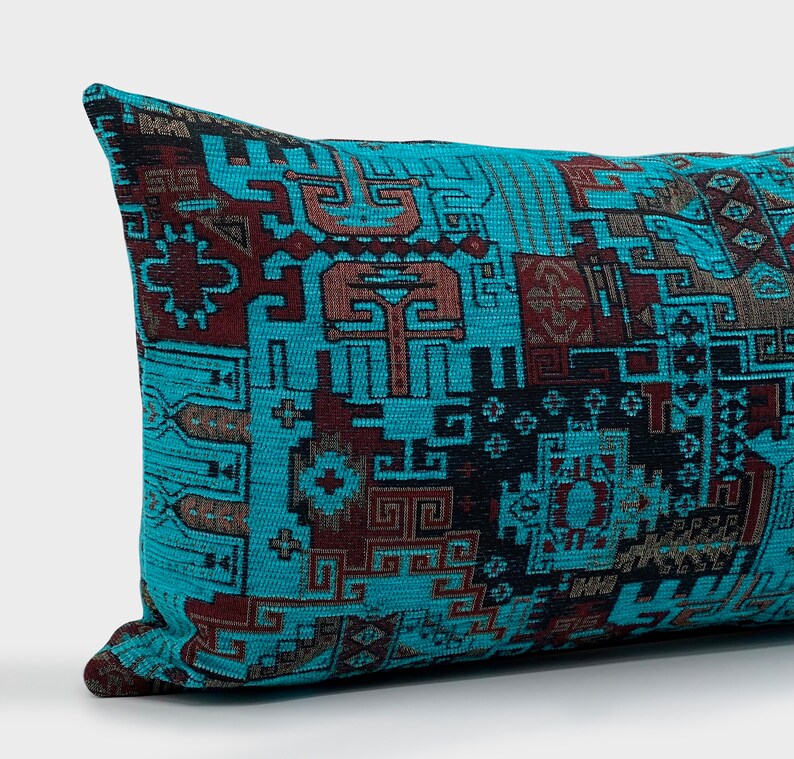 May include: A rectangular cushion featuring a teal backdrop and a geometric design in brown and black hues. The cushion has a woven texture and is designed for home decor, with a length of approximately 40 cm.
