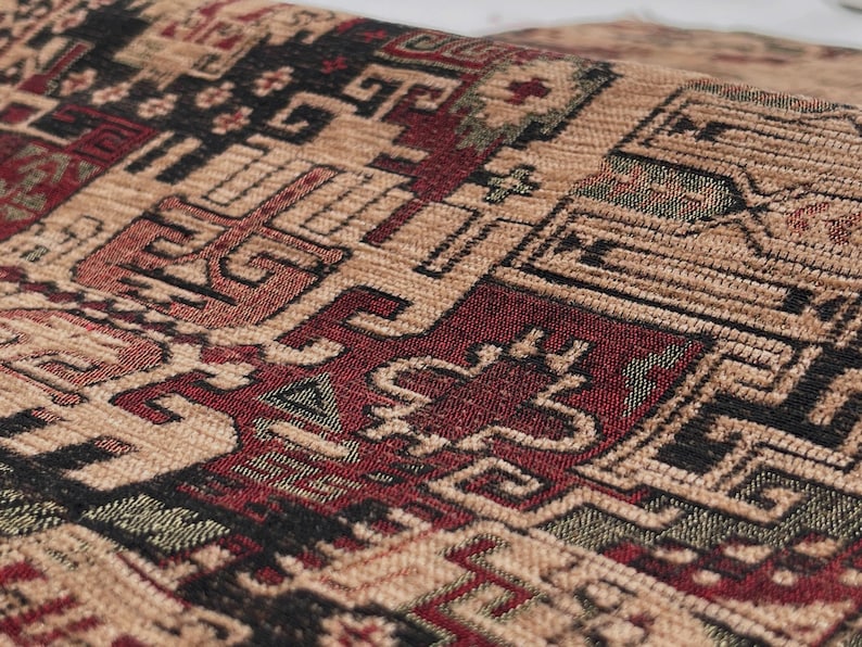 May include: A woven fabric featuring a dense, intricate geometric pattern in shades of deep red, black, and tan. The textile displays repeating angular motifs and interconnected shapes across its textured surface, creating a complex visual design.