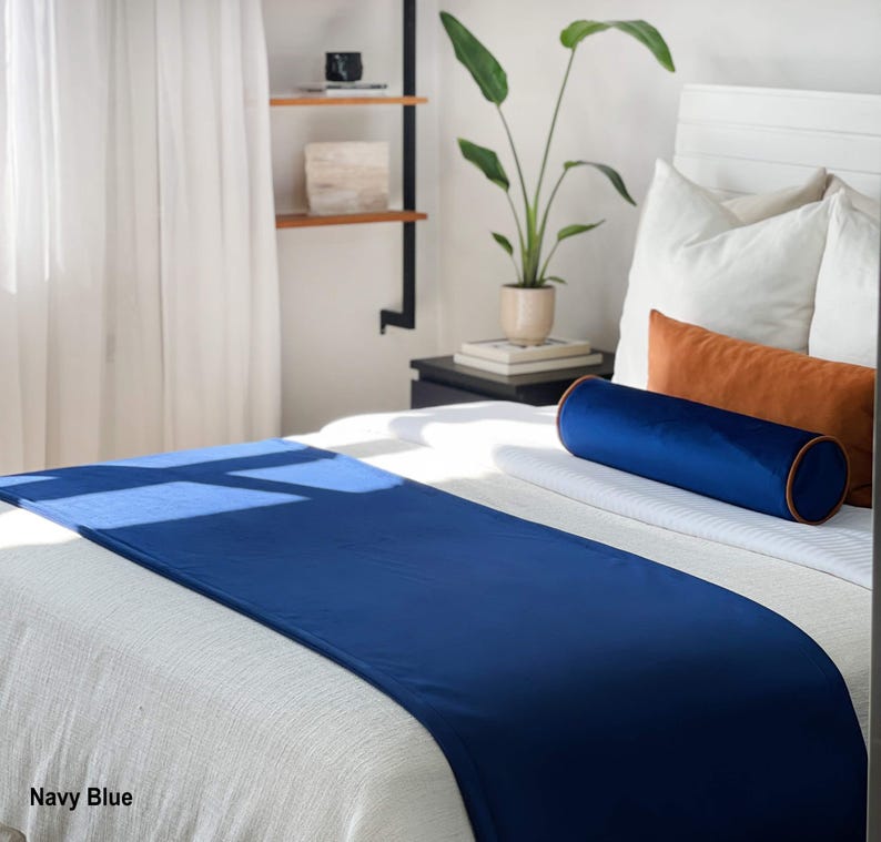 Peut inclure: Un chemin de lit bleu marine sur un lit blanc, avec un traversin bleu marine assorti et des coussins d'appoint orange. Le lit est fait de draps et d'oreillers blancs. Le texte "Navy Blue" est visible en bas &agrave; gauche.