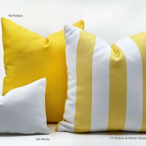 Op de afbeelding: Een verzameling decoratieve kussens in verschillende kleuren en patronen. De kussens omvatten effen gele, witte en geel-wit gestreepte ontwerpen. De kussens zijn gelabeld met hun kleur- of patroonnamen.