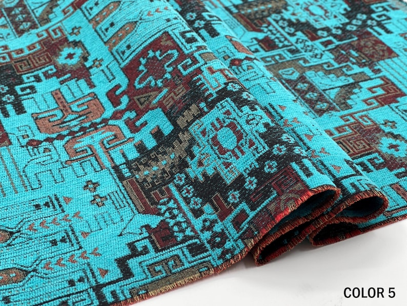 May include: A folded piece of fabric featuring a vibrant turquoise background with intricate geometric patterns in black and deep red. The textile displays a repeating design of interconnected shapes and lines, with the text COLOR 5 visible.