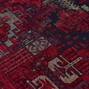 May include: A woven textile fabric featuring a dense, intricate geometric pattern in deep shades of crimson red, black, and muted gold. The surface displays a textured, multi-layered appearance with repeating angular motifs and interconnected lines.