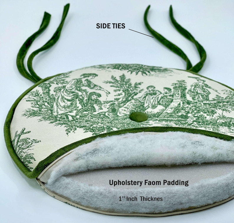 May include: An oval cushion with a green and white toile pattern, featuring a 1-inch thick upholstery foam padding. The cushion has green side ties and a green button. The text "Side Ties" and "Upholstery Foam Padding 1" Inch Thicknes" are visible.