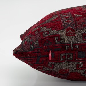 May include: Red and black patterned throw pillow with a zipper closure.
