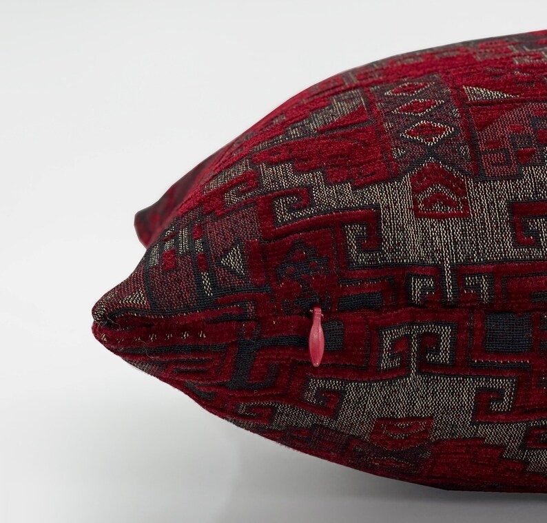 May include: Red and black patterned throw pillow with a zipper closure.