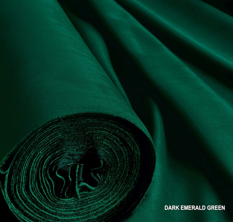 Puede incluir: Un rollo de tela verde esmeralda oscuro. La tela es lisa y tiene un ligero brillo.