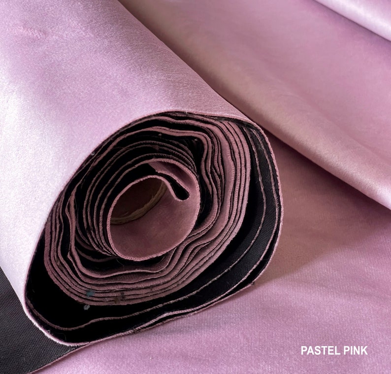 Puede incluir: Un rollo de tela rosa pastel, bien enrollado y listo para ser utilizado en proyectos de costura o manualidades.