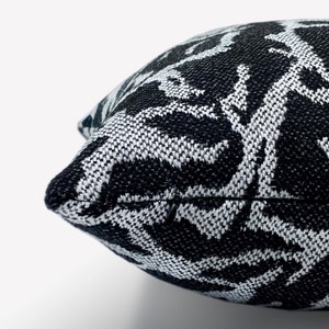 May include: Black and white patterned throw pillow with a zipper closure.