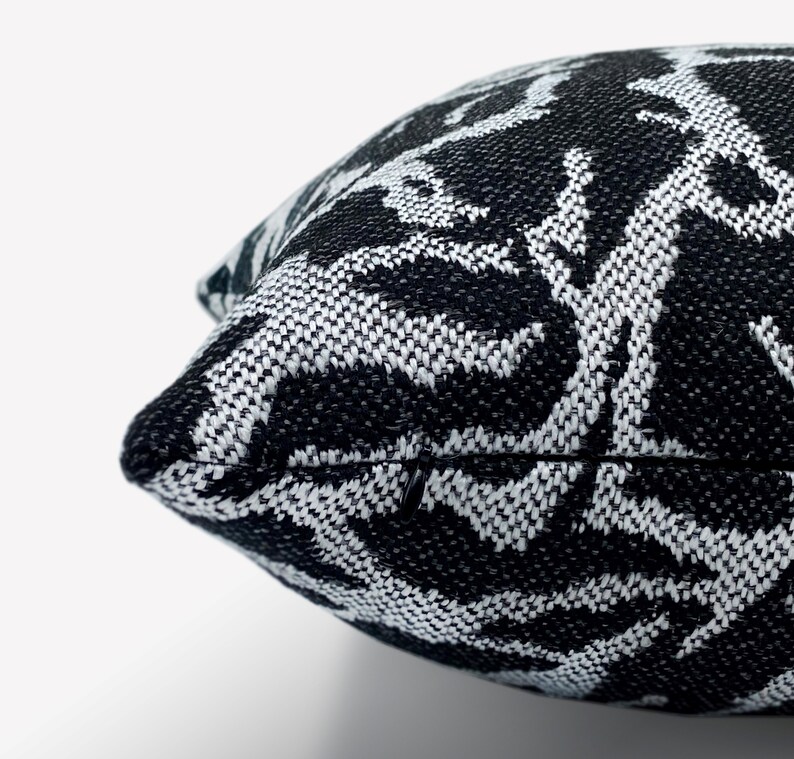 May include: Black and white patterned throw pillow with a zipper closure.
