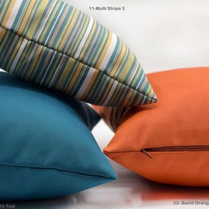 Op de afbeelding: Een set van drie keramische mokken met een gespikkelde, cr&egrave;mekleurige glazuur. Elke mok heeft een handgeschilderd ontwerp: een blauw en groen blad, een gele bloem en een rode bes. De mokken hebben een eenvoudige, afgeronde vorm.