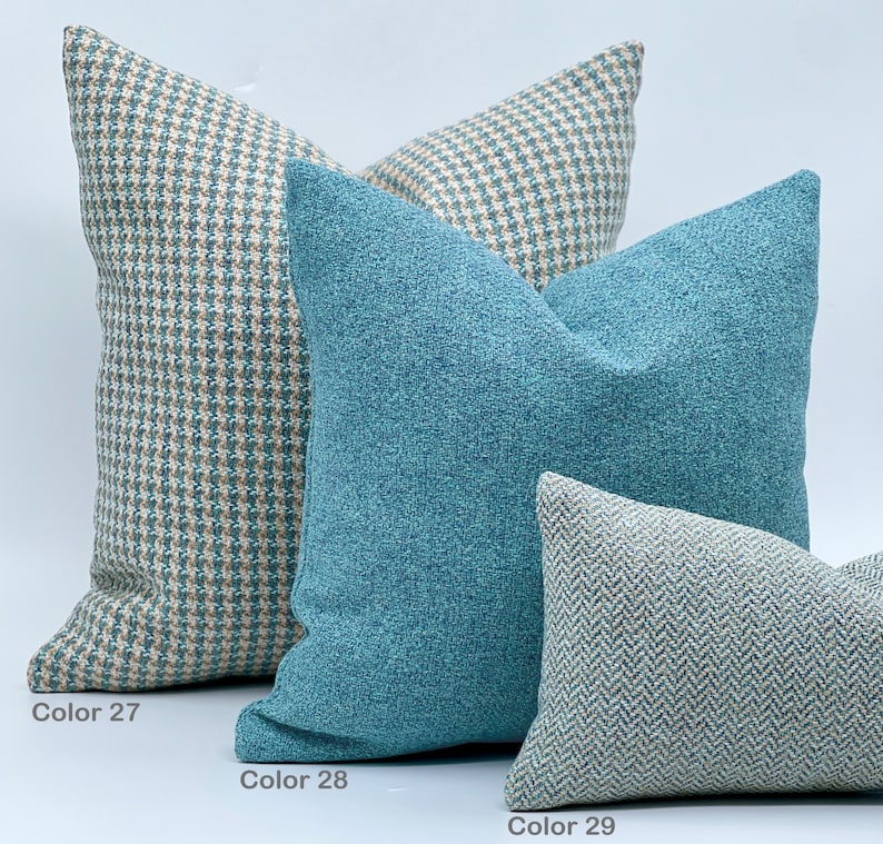 Puede incluir: Tres almohadas decorativas en varios patrones y colores. La almohada de abajo es un patr&oacute;n de espiga verde claro y blanco. La almohada del medio es azul turquesa s&oacute;lido. La almohada de arriba es un patr&oacute;n de cuadros vichy azul claro y beige. Las almohadas est&aacute;n etiquetadas como "Color 27", "Color 28" y "Color 29".
