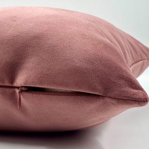 May include: A dusty rose velvet pillow with a zipper closure.