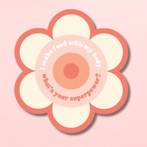 Puede incluir: Adhesivo con forma de flor con fondo rosa claro y borde blanco. El centro contiene el texto "I make food with my body. What's your superpower?" en círculo. Los pétalos son de color rosa claro.
