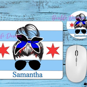 May include: A blue and white mouse pad with a stylized illustration of a woman with a bun, sunglasses, and a blue ribbon. The woman is wearing a blue and red bandana. The mouse pad has a red star on each side and the text "Samantha" at the bottom.