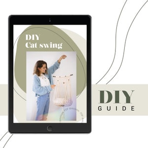 Op de afbeelding: Een digitale doe-het-zelfgids op een tabletscherm. De gids toont een macramé kattenzwaai. De tekst "DIY Cat swing" is op het scherm te zien. De afbeelding toont een persoon die de kattenzwaai vasthoudt. De woorden "DIY GUIDE" worden aan de rechterkant van het scherm weergegeven.