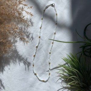 Collar de cuentas doradas y blancas