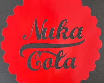 May include: Red and black Nuka Cola logo on a bottle cap shaped sticker.