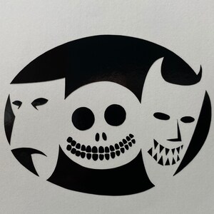 May include: Black and white silhouette of three faces: a skull with a wide grin, a sad-looking mask, and a devilish face with horns. The faces are arranged in a circle.
