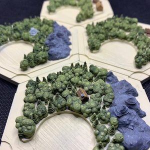 May include: A 3D printed hexagonal game board with a forest theme. The board features a variety of terrain, including trees, mountains, and a small cabin. The board is made of a light beige plastic and is designed for use with miniature figures.