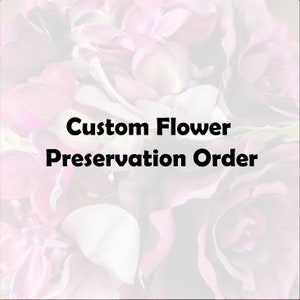 May include: Image features the text "Custom Flower Preservation Order" in bold black font, set against a soft-focus backdrop of pink and white flower petals. The overall aesthetic suggests floral preservation services.