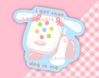 May include: A sticker featuring a cartoon dog design with the text "i got that dog in me." The dog is white with colorful spots and pink accents, set against a light blue background. The sticker has a pink and white gingham pattern.