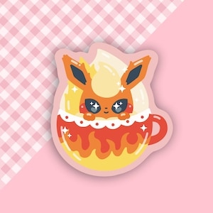 Puede incluir: Una ilustración de dibujos animados de un Pokémon de tipo fuego, Flareon, en una taza roja y amarilla con un borde blanco y un asa. La taza está llena de un líquido amarillo y naranja, y el Pokémon asoma por la parte superior.