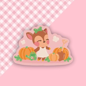 May include: A cartoon deer wearing a white dress and a green bow stands in front of a pile of orange pumpkins. A green watering can and a brown shovel are also in the image.