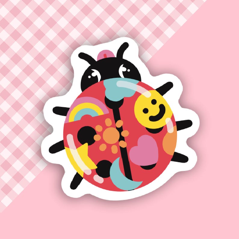 May include: A red ladybug sticker with a white outline. The ladybug is decorated with colorful patterns, including a rainbow, a sun, a heart, a star, a smiley face, and a crescent moon.