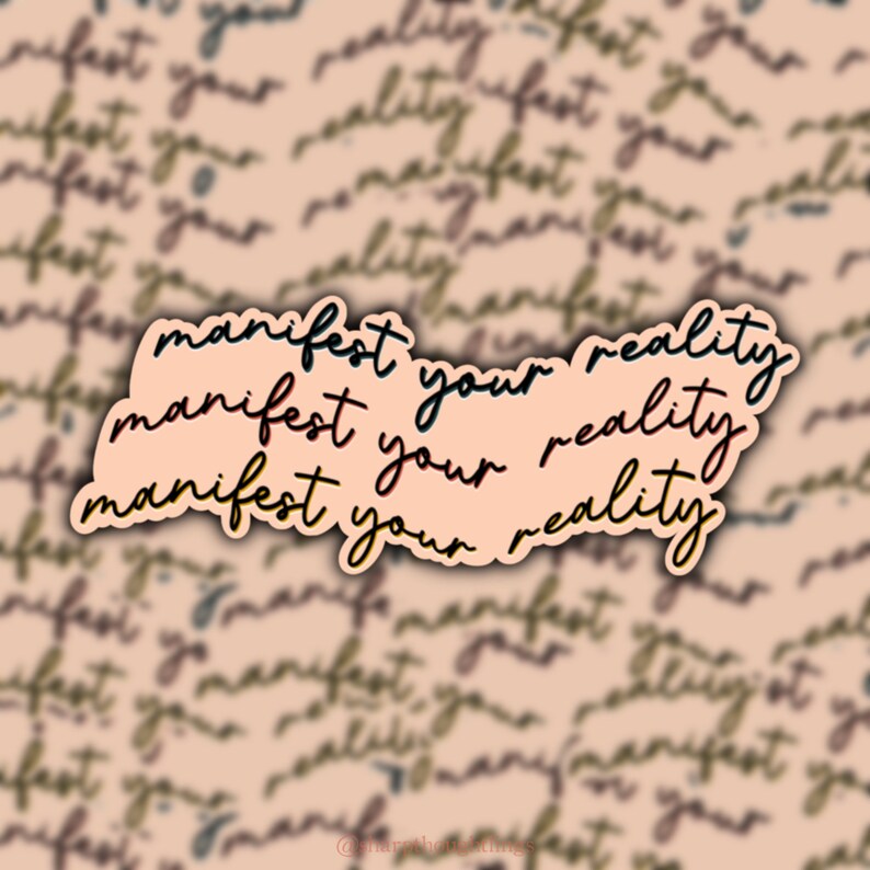 May include: A pink sticker with the text "manifest your reality" repeated three times in black and red lettering. The sticker is on a background of blurred text that says "manifest your reality".