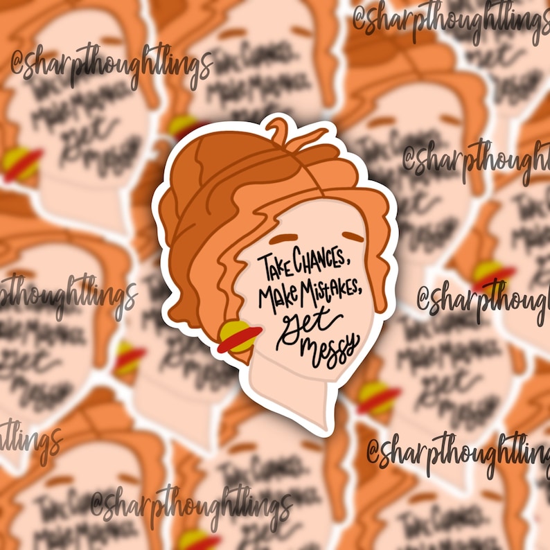 May include: A sticker featuring a cartoon illustration of a woman with red hair and a red and yellow planet behind her. The text on the sticker reads "Take chances, make mistakes, get messy."