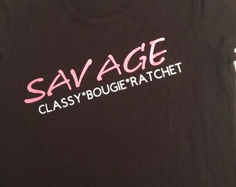 Savage women’s T-shirt in black with pink and white lettering.