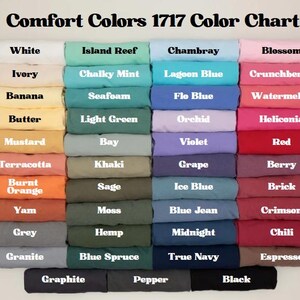May include: A color chart titled "Comfort Colors 1717 Color Chart" displays a variety of fabric colors. The chart includes shades like white, ivory, banana, butter, mustard, terracotta, burnt orange, yam, grey, and granite.