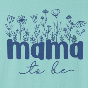 May include: A light teal graphic with the words "mama to be" in dark blue, with a floral design above the word "mama". The flowers are outlined in dark blue.