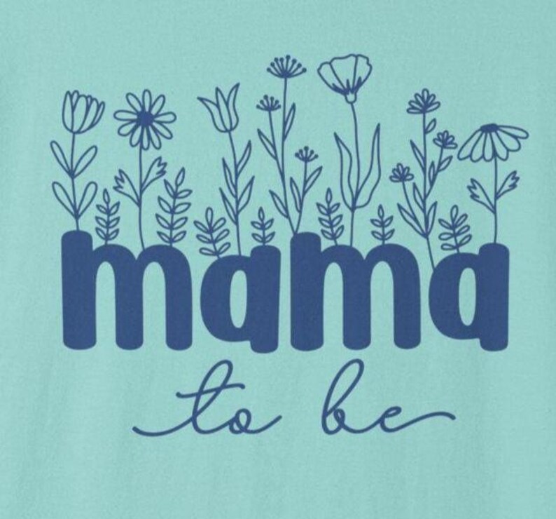May include: A light teal graphic with the words "mama to be" in dark blue, with a floral design above the word "mama". The flowers are outlined in dark blue.