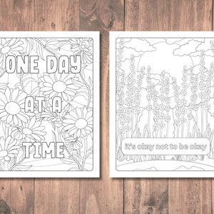 May include: Two black and white coloring pages. The first page features a floral design with the text "One Day At A Time". The second page features a field of lavender with the text "It's okay not to be okay".