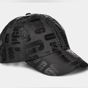May include: A black baseball cap with a repeating pattern of the word "Ugg" in a bold, embossed font.