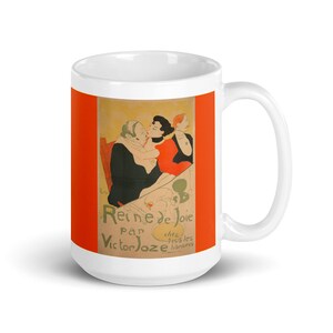 May include: White ceramic mug with a colorful image of a vintage poster for a play called "Reine de Joie" by Victor Joze. The poster features three people in a scene with a red background.