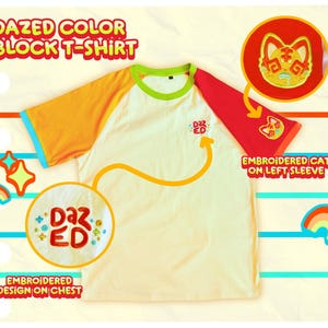 Pode incluir: Camiseta de bloco de cores creme com mangas laranja e vermelhas, gola verde e acabamento azul nas mangas. A camisa apresenta desenhos bordados: "DAZED" no peito e um gato na manga esquerda. O texto na imagem diz "DAZED COLOR BLOCK T-SHIRT".