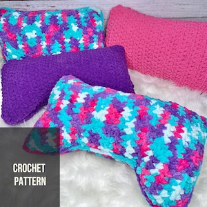 May include: Four crochet pillows in various colors. One is a solid pink, another is solid purple, and two are patterned with pink, blue, and white. The text "CROCHET PATTERN" is in the lower left corner.