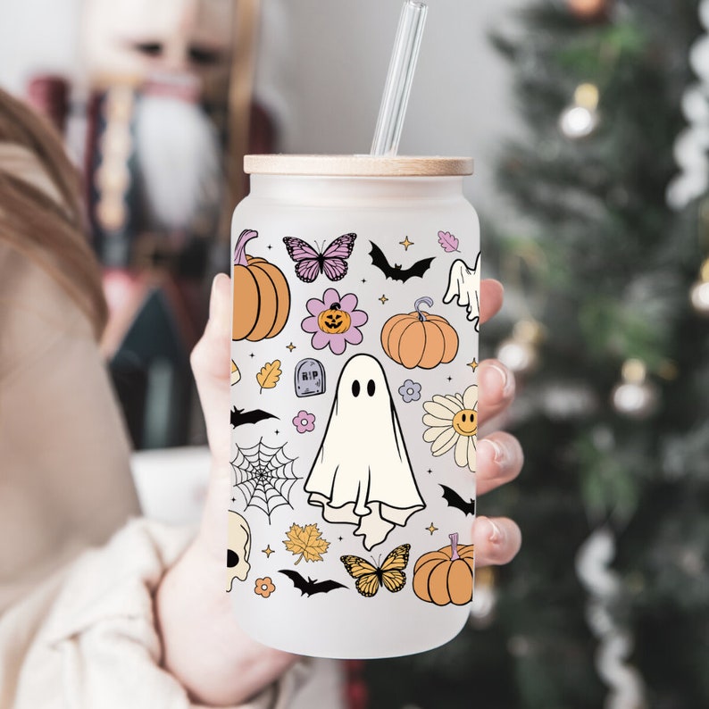 Pu&ograve; includere: Bicchiere in vetro smerigliato con coperchio in bamb&ugrave; e cannuccia in vetro. Il bicchiere &egrave; decorato con un motivo a tema Halloween con zucche, fantasmi, pipistrelli, fiori e farfalle. Il design &egrave; nei toni dell'arancione, viola e bianco.