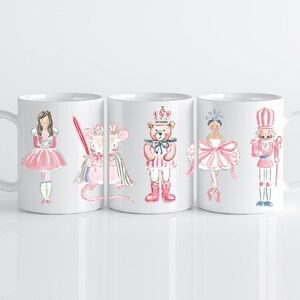 May include: White ceramic mugs featuring watercolor illustrations of characters from The Nutcracker ballet. The designs include a ballerina, a mouse king, a teddy bear, and a nutcracker soldier, all in pink and white.
