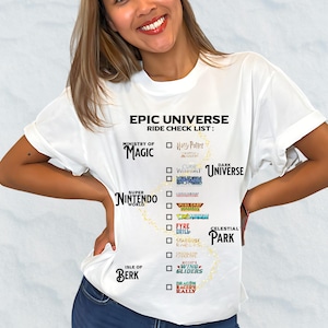 Puede incluir: Camiseta blanca con el texto "EPIC UNIVERSE RIDE CHECK LIST" y nombres de atracciones temáticas y casillas de verificación. La camiseta incluye logotipos de "Ministry of Magic", "Super Nintendo World" e "Isle of Berk".