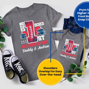 May include: A gray short-sleeved t-shirt with a red and blue football design and the text "Our 1st Father's Day 2023 Daddy & Andrew". A gray short-sleeved bodysuit with the same design and text. The shirts are laid out on a white surface with a pair of black sneakers and green plants.